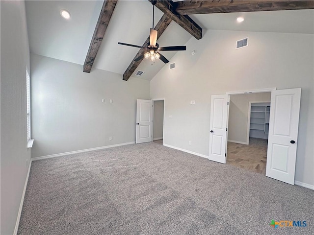 unfurnished bedroom with visible vents, carpet flooring, beam ceiling, and baseboards