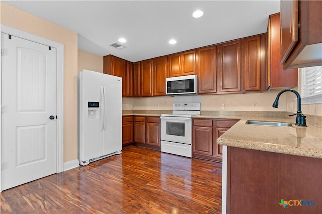 9108 Sage Loop Ct, Temple, TX 76502 - kitchen featuring white appliances, a sink, dark wood-style floors, recessed lighting, and brown cabinetry