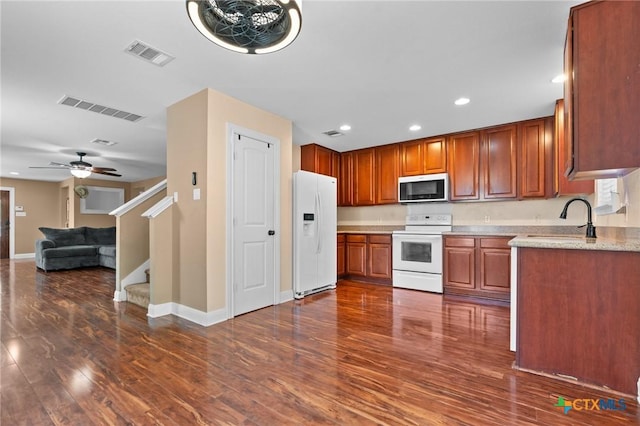 9108 Sage Loop Ct, Temple, TX 76502 - kitchen with white appliances, a sink, recessed lighting, dark wood finished floors, and brown cabinets
