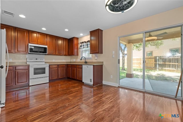 9108 Sage Loop Ct, Temple, TX 76502 - kitchen featuring white appliances, dark wood-style floors, light countertops, a sink, and recessed lighting