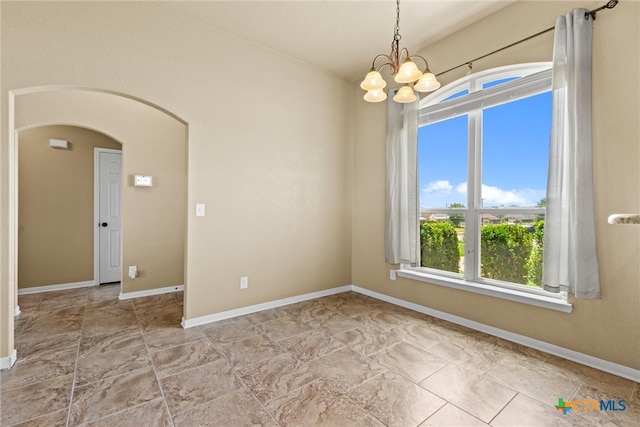 empty room with plenty of natural light and an inviting chandelier