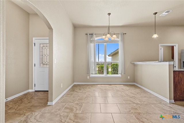 unfurnished dining area featuring a chandelier