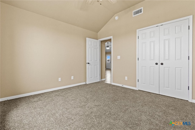 unfurnished bedroom with carpet, vaulted ceiling, and a closet