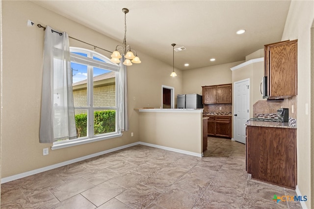 kitchen with hanging light fixtures, stainless steel appliances, decorative backsplash, and a notable chandelier