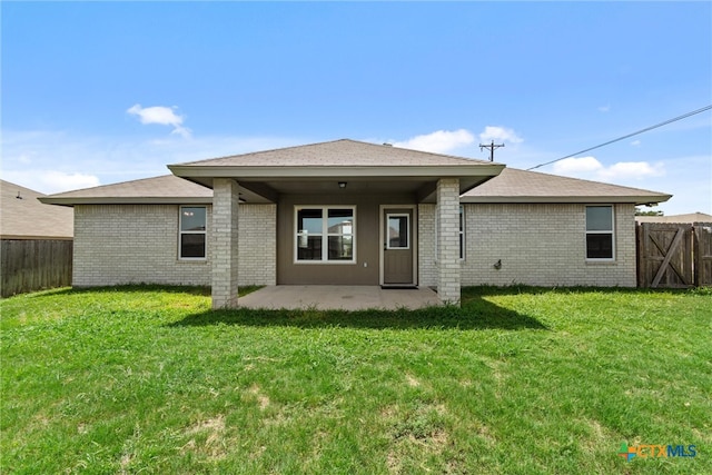 rear view of house featuring a yard and a patio