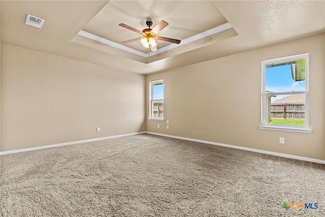 carpeted empty room featuring ornamental molding, a tray ceiling, and ceiling fan