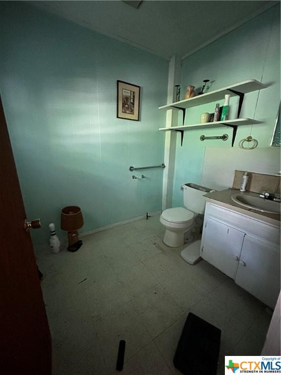 903 N Cherry St, Seguin, TX 78155 - half bathroom with toilet, vanity, and tile patterned floors