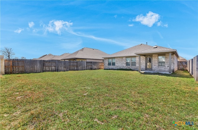 132 Periwinkle Ln, Bastrop, TX 78602 - rear view of house with a yard, a fenced backyard, and brick siding