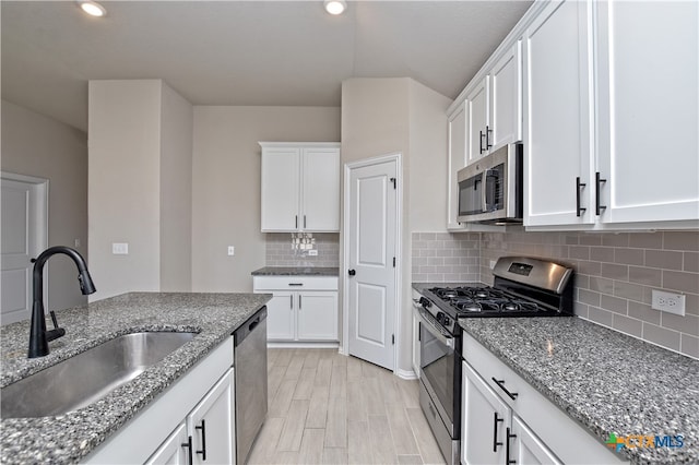 132 Periwinkle Ln, Bastrop, TX 78602 - kitchen with white cabinets, appliances with stainless steel finishes, stone countertops, and a sink