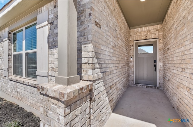 view of exterior entry featuring brick siding