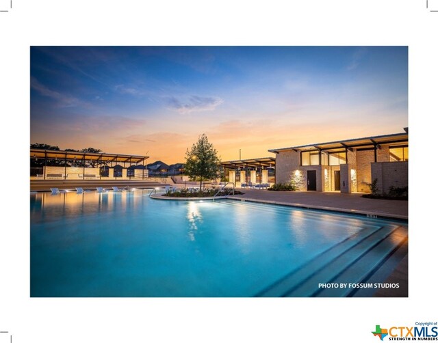 view of pool at dusk