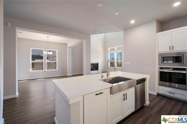 kitchen with appliances with stainless steel finishes, dark wood-type flooring, sink, and plenty of natural light