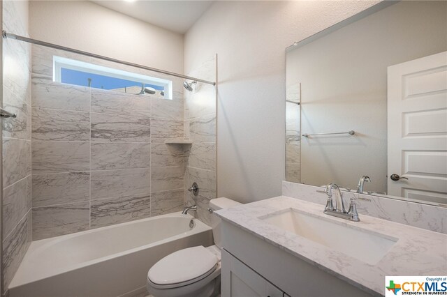 full bathroom with toilet, vanity, and tiled shower / bath