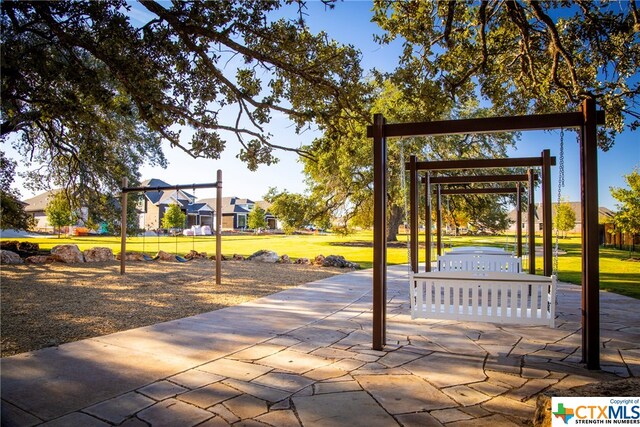 view of property's community with a playground and a lawn