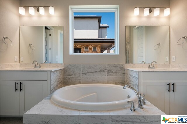 bathroom with a relaxing tiled tub and vanity