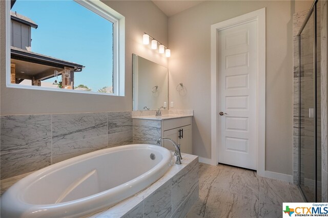 bathroom with vanity and tiled tub