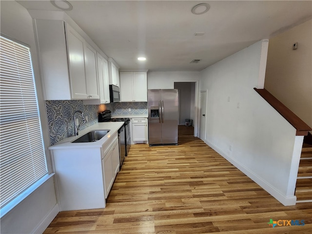 kitchen featuring light hardwood / wood-style flooring, white cabinets, sink, and stainless steel appliances