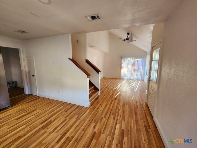 unfurnished living room featuring ceiling fan, lofted ceiling, and light hardwood / wood-style floors