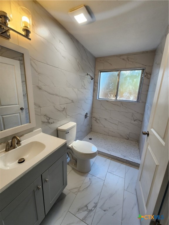 bathroom featuring tile walls, vanity, toilet, and a shower