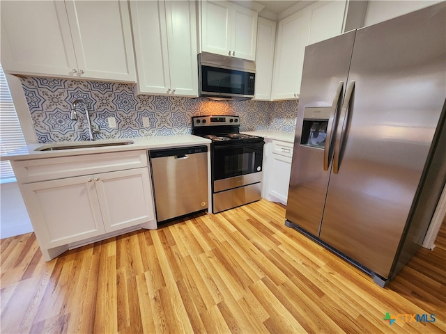 kitchen with white cabinetry, light wood-type flooring, appliances with stainless steel finishes, and sink