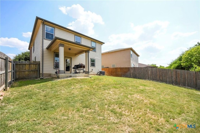 rear view of house with a patio area, central AC, and a yard