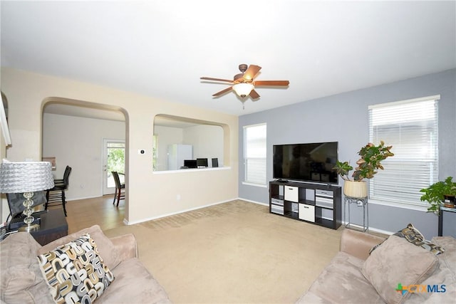 carpeted living room with ceiling fan and a healthy amount of sunlight