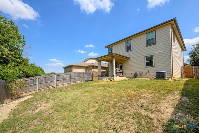 rear view of property with a lawn, a patio area, and central AC