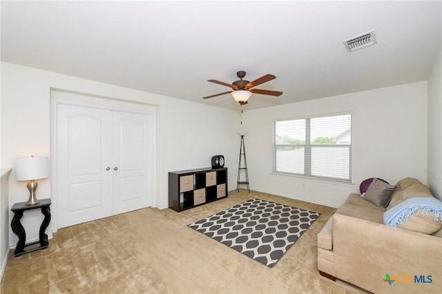 carpeted living room with ceiling fan