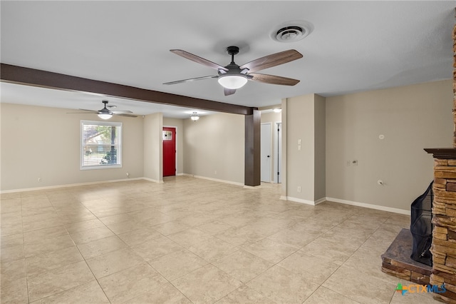 unfurnished living room with a stone fireplace, ceiling fan, and beam ceiling