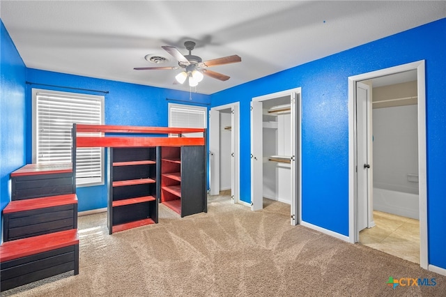 unfurnished bedroom with carpet flooring, ceiling fan, and connected bathroom