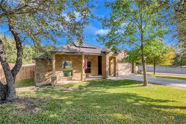 view of front of property featuring solar panels and a front lawn