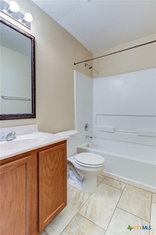 full bathroom featuring toilet, tile patterned flooring, washtub / shower combination, a textured ceiling, and vanity