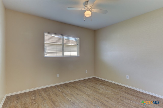 spare room with ceiling fan and light wood-type flooring