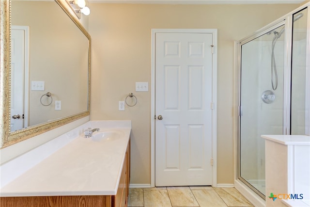 bathroom with tile patterned floors, vanity, and a shower with door