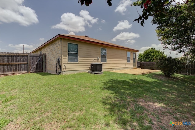 rear view of house with a yard, central AC, and a patio