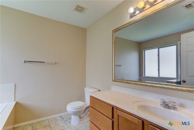 bathroom with toilet, a tub to relax in, vanity, and tile patterned flooring