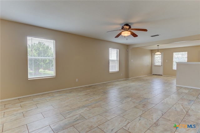 unfurnished room with a healthy amount of sunlight and ceiling fan