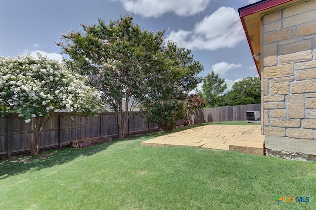 view of yard with central AC unit and a patio