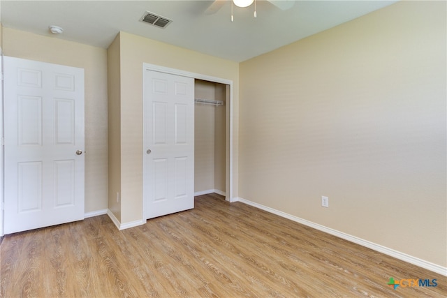 unfurnished bedroom featuring light hardwood / wood-style floors, ceiling fan, and a closet