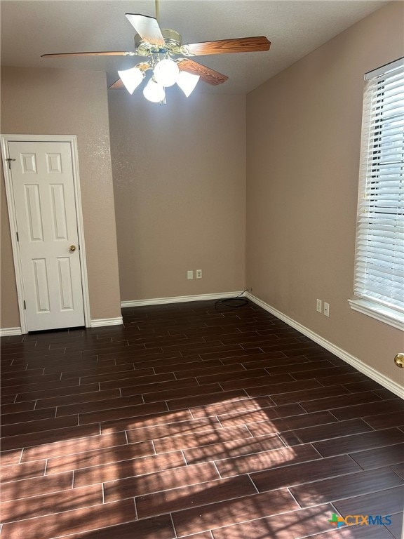 unfurnished room with dark hardwood / wood-style flooring and ceiling fan