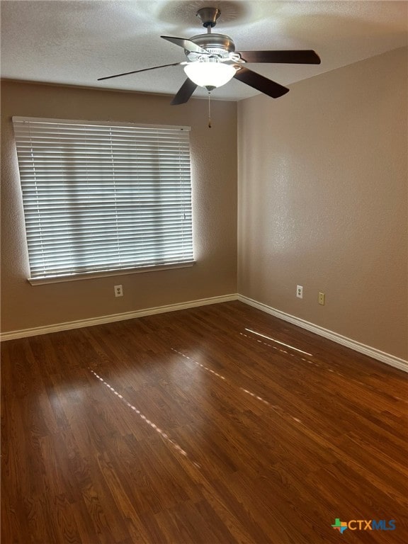 spare room with dark hardwood / wood-style flooring and ceiling fan