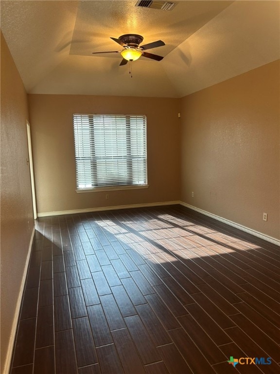 unfurnished room featuring dark hardwood / wood-style flooring, lofted ceiling, a textured ceiling, and ceiling fan