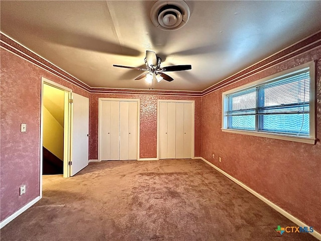 203 Hampshire St, Victoria, TX 77904 - unfurnished bedroom with carpet floors, two closets, ceiling fan, and crown molding
