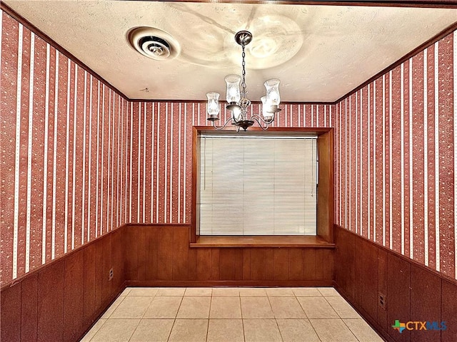 203 Hampshire St, Victoria, TX 77904 - unfurnished dining area featuring wallpapered walls, wainscoting, a chandelier, a textured ceiling, and tile patterned flooring