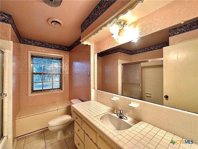 203 Hampshire St, Victoria, TX 77904 - bathroom featuring a shower with shower door, toilet, tile patterned flooring, tasteful backsplash, and vanity