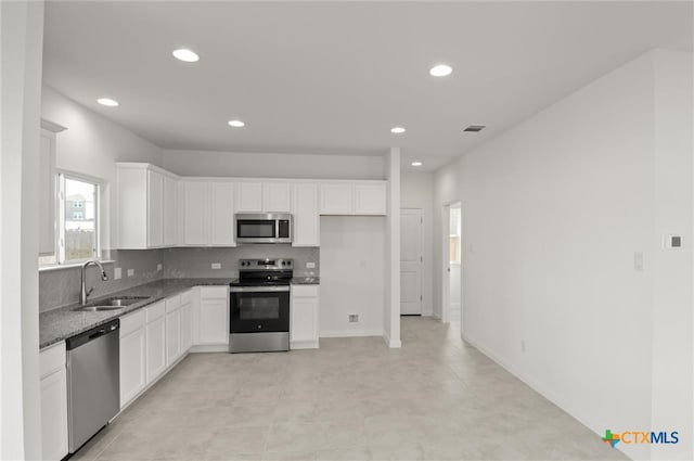 kitchen with white cabinets, stainless steel appliances, tasteful backsplash, and sink