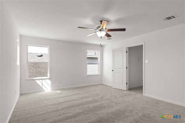 unfurnished room with ceiling fan and light colored carpet