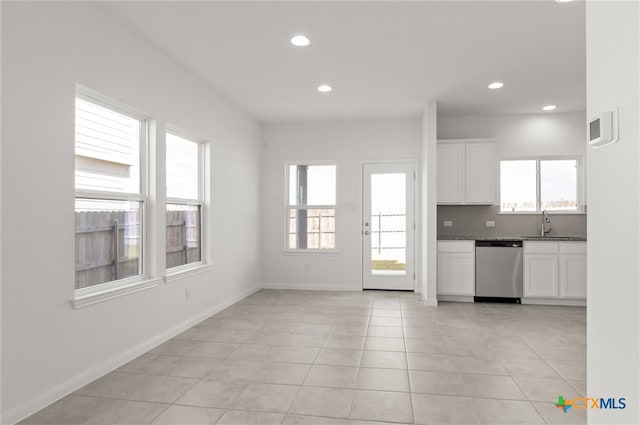 kitchen featuring white cabinets, light tile patterned floors, and stainless steel dishwasher