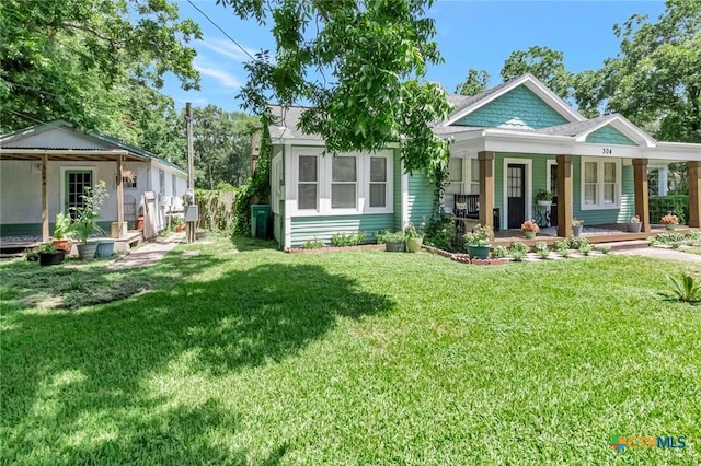 304 W Putnam, Ganado, TX 77962 - view of front of home featuring covered porch and a front lawn