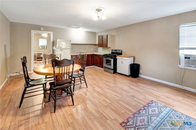 304 W Putnam, Ganado, TX 77962 - dining space with light wood-type flooring, baseboards, and cooling unit